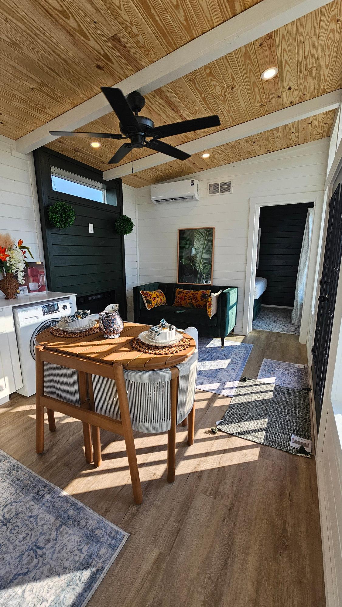 Decorated dining and living area with green accent wall