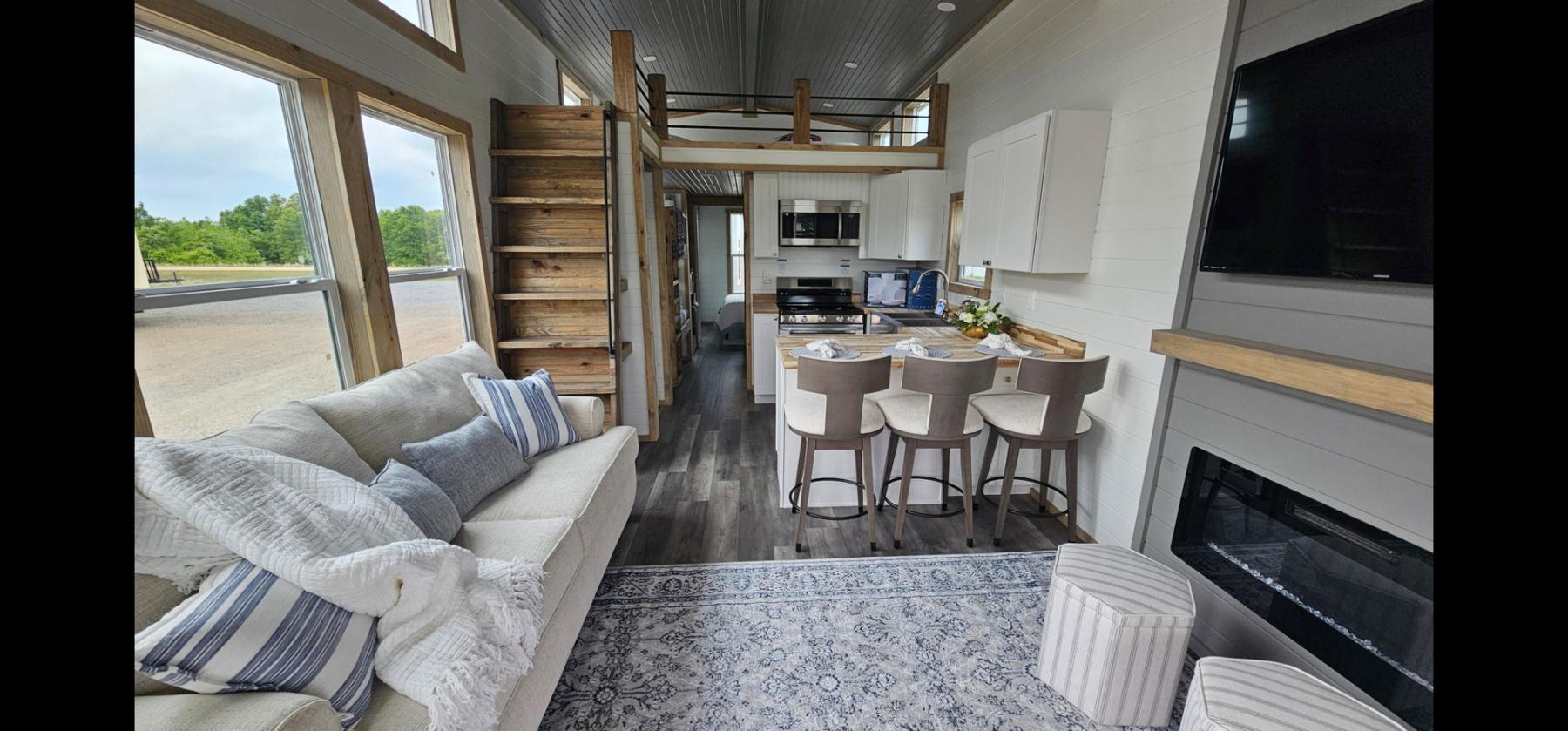 Decorated living room with sofa, loft ladder and breakfast bar