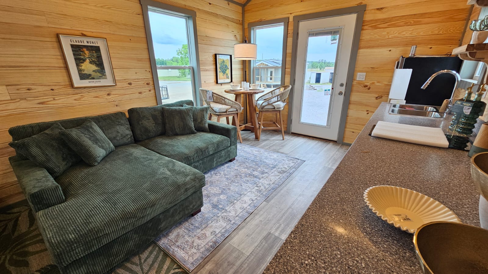 Decorated living room in a Phoenix park model home with knotty pine walls and a sectional sofa